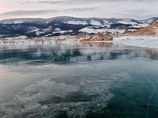 Baikal Lake in winter. Beautiful landscape with mountains reflected in ice of frozen Small Sea