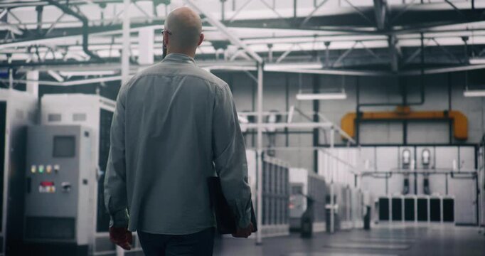 Professional Inspecting IT Infrastructure. Bearded Engineer Walks Between Rows of Servers, Seemingly Conducting Silent Technical Audit of Cloud Architecture. Technical Control and System Integrity.