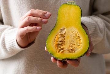 Half butternut squash pumpkin holding by woman hand