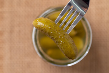 Pickled cucumber or Gherkin pickle with fork and glass jar, Top view