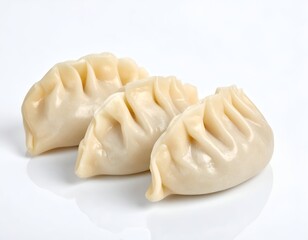 Three cooked dumplings, close-up, against white background