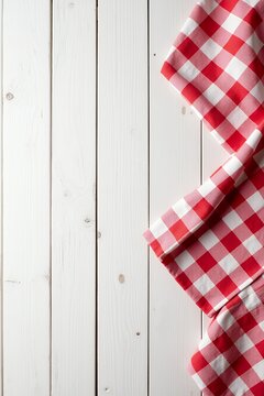 Red checkered cloth draped over a white wooden table surface viewed from directly above