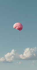 Pink brain balloon floats serenely above clouds in a clear, blue sky