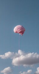 Floating pink brain, tethered by cord, against blue sky with scattered clouds