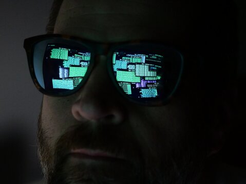 Man Hacking at Terminal Command Prompt Running Networks Scans and Packet Captures - Reflection in Glasses Black Hat Concept - Powered by Adobe