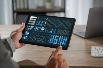 man with Chart businessman reviewing management data as a man tracks chart growth, profit, statistic, and success through business analytics on a tablet.