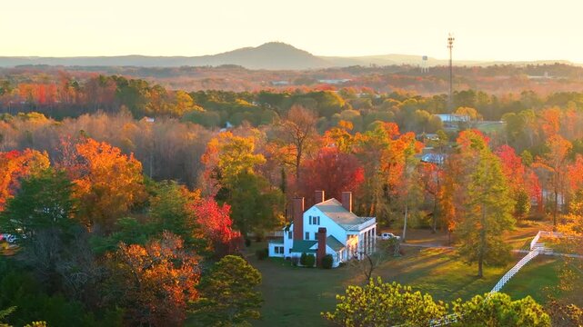 Large country homes surrounded by golden autumn woods, warm sunlight highlighting the rustic charm of rural living in the southern landscape.