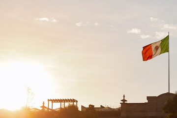 Mexican national flag waving on the rooftop of the municipal palace at sunset in Toluca, Mexico