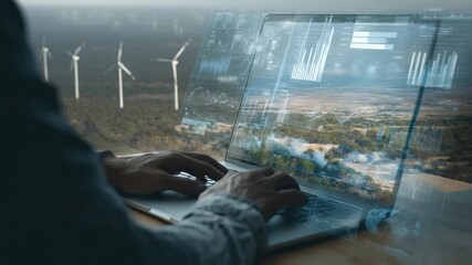 Wind Energy Management: A close-up shot of a person using a laptop to monitor and manage wind energy, with virtual displays overlaying a landscape of wind turbines. - Powered by Adobe