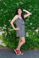 Woman laughing in front of a background of ivy.