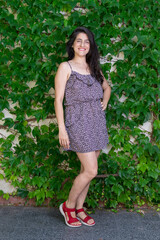 Woman laughing in front of a background of ivy.