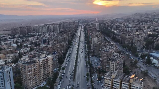 Aerial shot captures the Syrian capital at sunset, showing the city&rsquo;s skyline, streets, and urban areas as daylight fades over the capital.