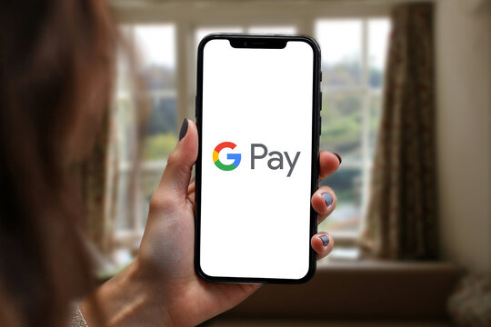 Woman holding smartphone with Google Pay app on screen