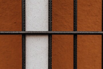 Fototapeta premium オレンジの壁と鉄の格子