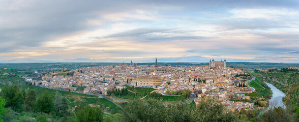 Aerial view of the historic city of Toledo in Spain during spring dusk. The Rio Tajo river flows around the city walls as a natural barrier.