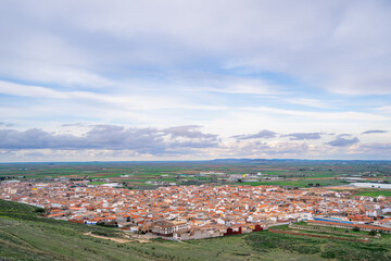 Aerial view of the traditional red roof houses in Consuegra, a historic stop on the Don Quixote route under a spring sky in Spain.