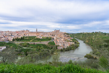 Panoramic view of Toledo, Spain during spring twilight. The ancient city sits on a hill surrounded by the Tagus River, creating a natural moat.