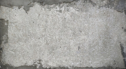 A grunge white concrete wall texture featuring a rough plaster surface with distressed edges revealing a gray underlying layer, ideal for abstract backgrounds.