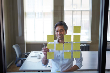 Business, man and reading sticky note in office for planning, schedule update and reminder. Glass,...