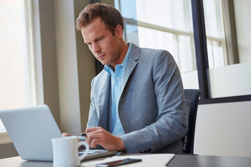 Fototapeta premium Man, lawyer and reading in office with laptop, case update and problem solving in investigation. Attorney, computer and research in law firm for compliance, review evidence and editing report