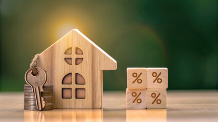 Percentage and wooden house sign symbol concept. Wooden house model with keys and percentage blocks on table.