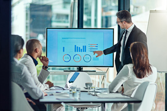 Screen, speaker and meeting with business man in office for presentation, sales pitch and profit returns. Data analysis, ROI feedback graph and investment dividends with employees for discussion