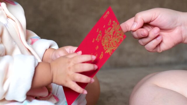 Adult hand giving a red ang pao envelope to a child, symbolizing blessings, love, luck, and prosperity during Lunar New Year or Chinese New Year