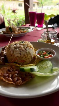Indonesian-style fried rice Nasi Goreng dinner table authentic restaurant Southeast Asia, vertical shot