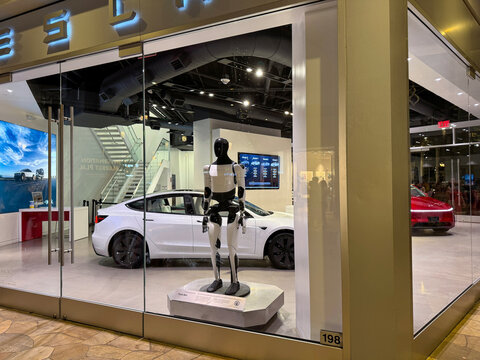 Tesla store with Tesla cars and humanoid robot in the showcase. AKA Optimus robot GEN 3. Waikiki, HI, USA - 25 December 2025