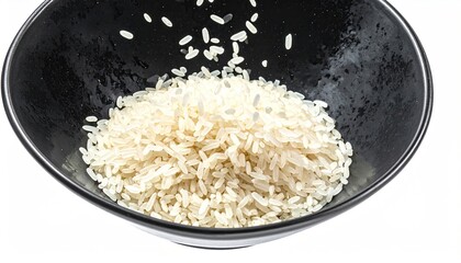 Close-up of rice grains falling into a black bowl, isolated on white