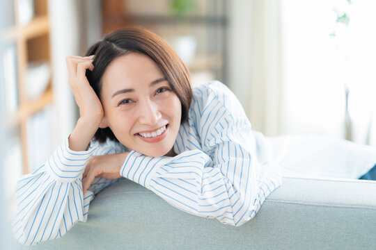 リビングのソファでくつろぐミドルの女性