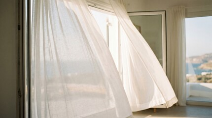 The gentle caress of a breeze animates translucent curtains. The wind billows them, inviting the light to dance within a bright, airy interior space.