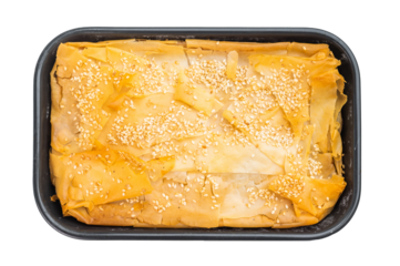 Greek Spanakopita baked in tray with phyllo pastry, spinach and cheese filling, topped with sesame seeds on wooden background