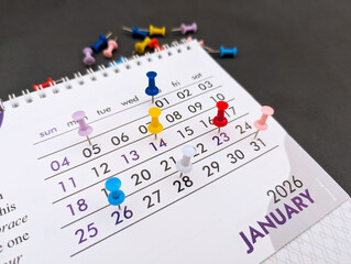 multiple push pins marked on monthly calendar 2026 for business events, schedule, appointment,...