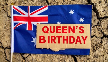 Australian flag on cracked earth with “QUEEN’S BIRTHDAY” sign