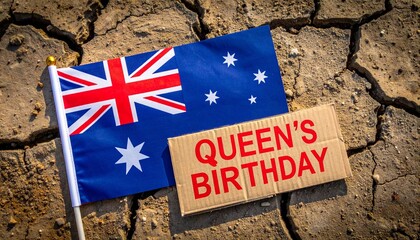 Australian flag on cracked earth with “QUEEN’S BIRTHDAY” sign