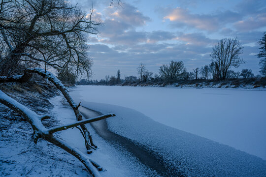Fluss im Winter mit Schnee und gefrorenem Wasser zur Morgend&auml;mmerung