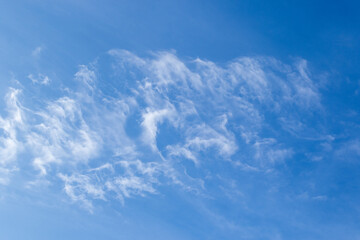 Fluffy and thin white clouds scattered in a bright blue southern African sky image for background use