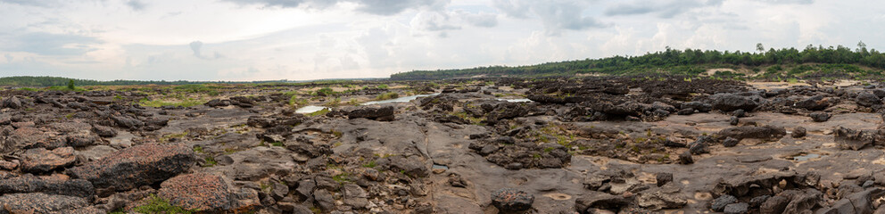Panoramic mountain and forest landscapes in autumn with a view of trees, hills, and a winding road through the valley under a cloudy sky