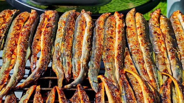 Golden, flame-grilled fish fillets sizzling on a hot rack, their crispy skin caramelized with char spots and glistening oils for a rich, smoky, freshly roasted look.