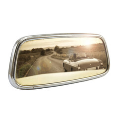 Vintage Car Reflected in Rearview Mirror on Open Country Road During Sunset