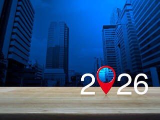 2026 letter with map pin location icon on wooden table over modern office city tower and skyscraper, Happy new year 2026 map pointer navigation concept