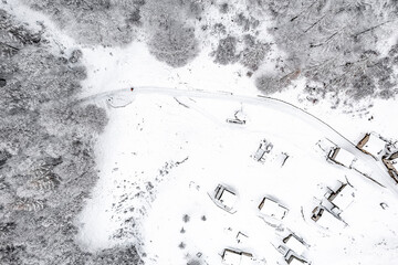 Hiker on footpath in the frozen forest, drone point of view