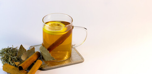 Herbal winter tea with lemon and cinnamon—styled with natural ingredients and copy space for...