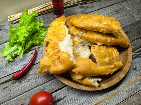 aked pieces of flat bread with cheese on a wooden plate