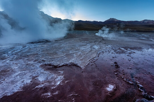 Steam rises from El Tatio geyser field in Chile before sunset