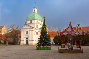 Christmas tree and Saint Kazimierz Church in New Town square in Warsaw Poland during winter day