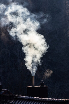 Smoke rising from a chimney of a wood stove on a rooftop in Wurzburg