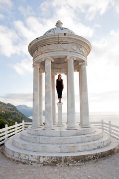 Person standing inside marble monopteros temple on Majorca coast