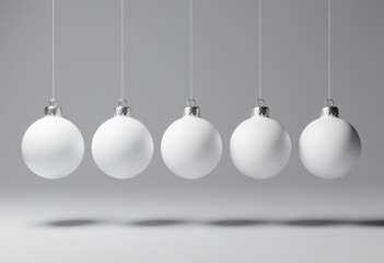 Minimalist white christmas ornaments hanging in a row against gray background